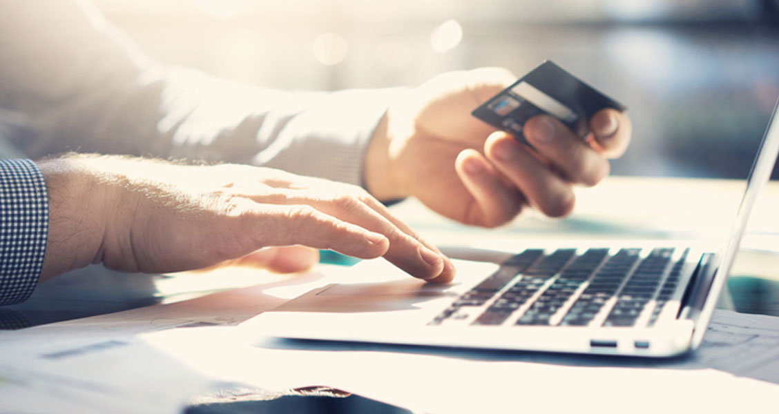Person using credit card to purchase an item on their laptop