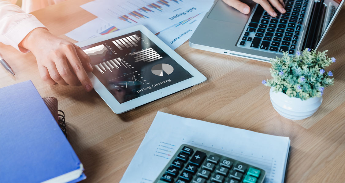 ipad, laptop and calculator on office desk