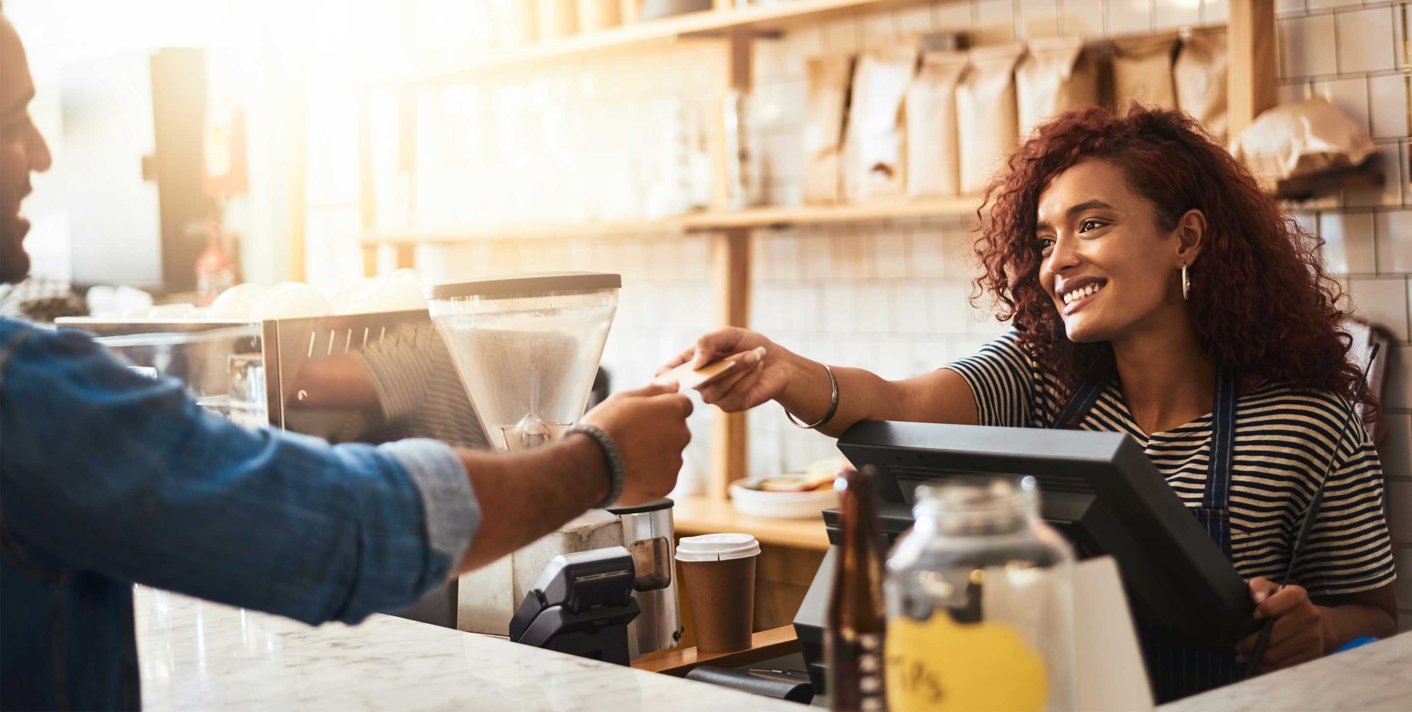 Person checking out order at a coffee shop with a credit card