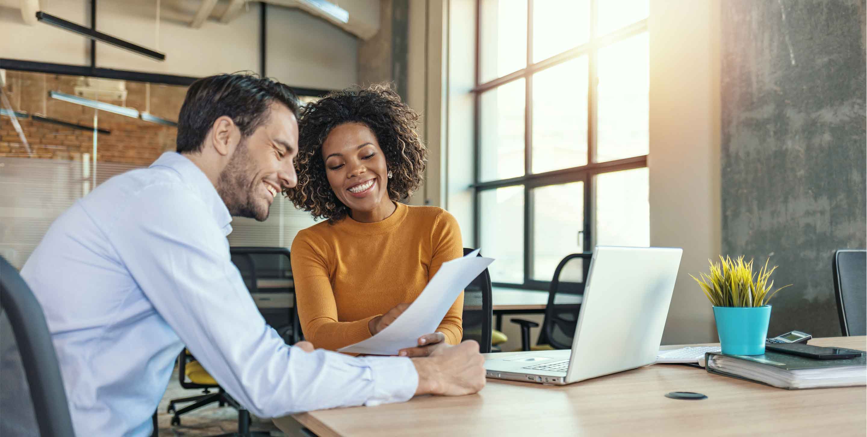 Two young business people having a successful meeting in modern office.