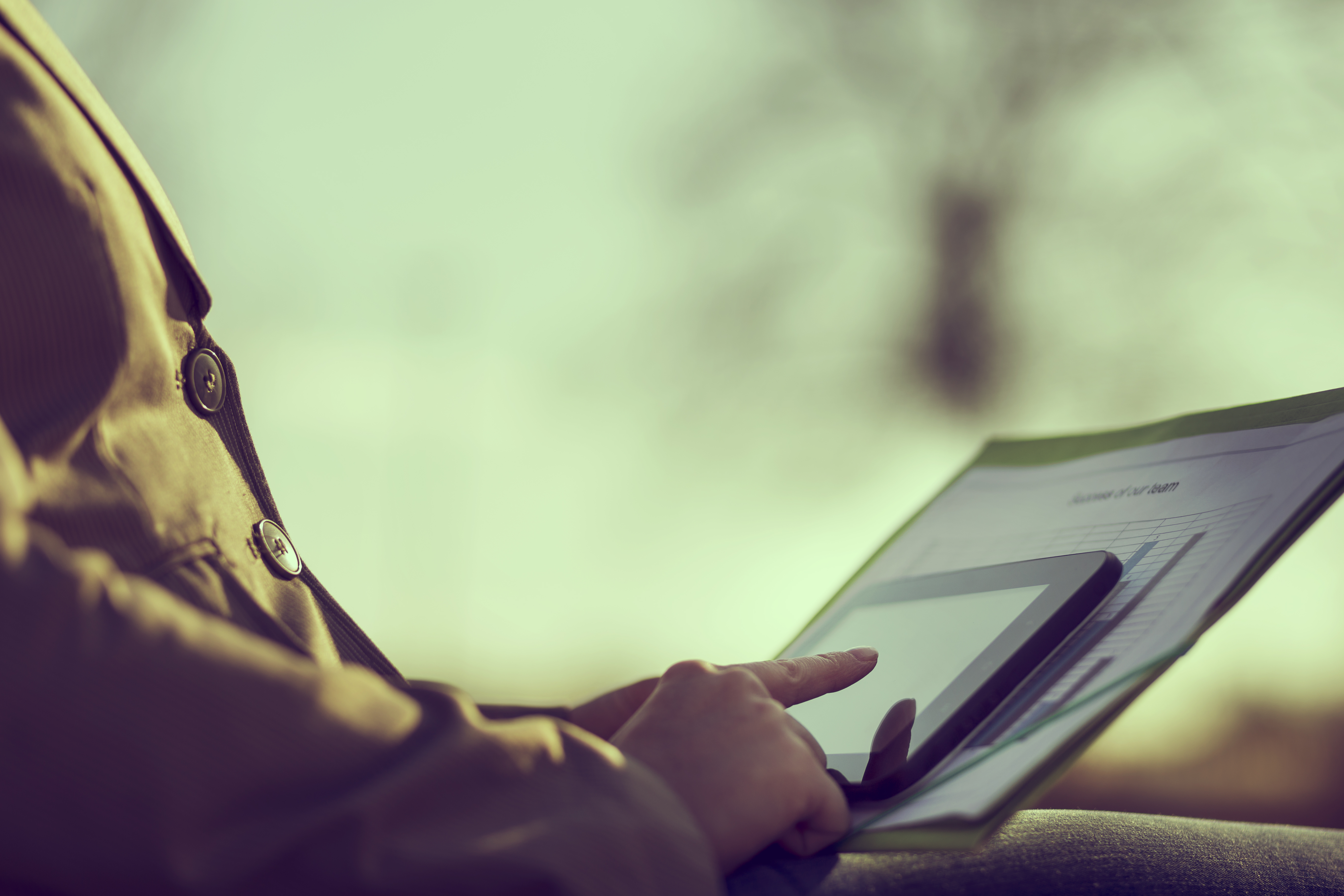 A person reading something on their phone and comparing it to a chart in their lap.