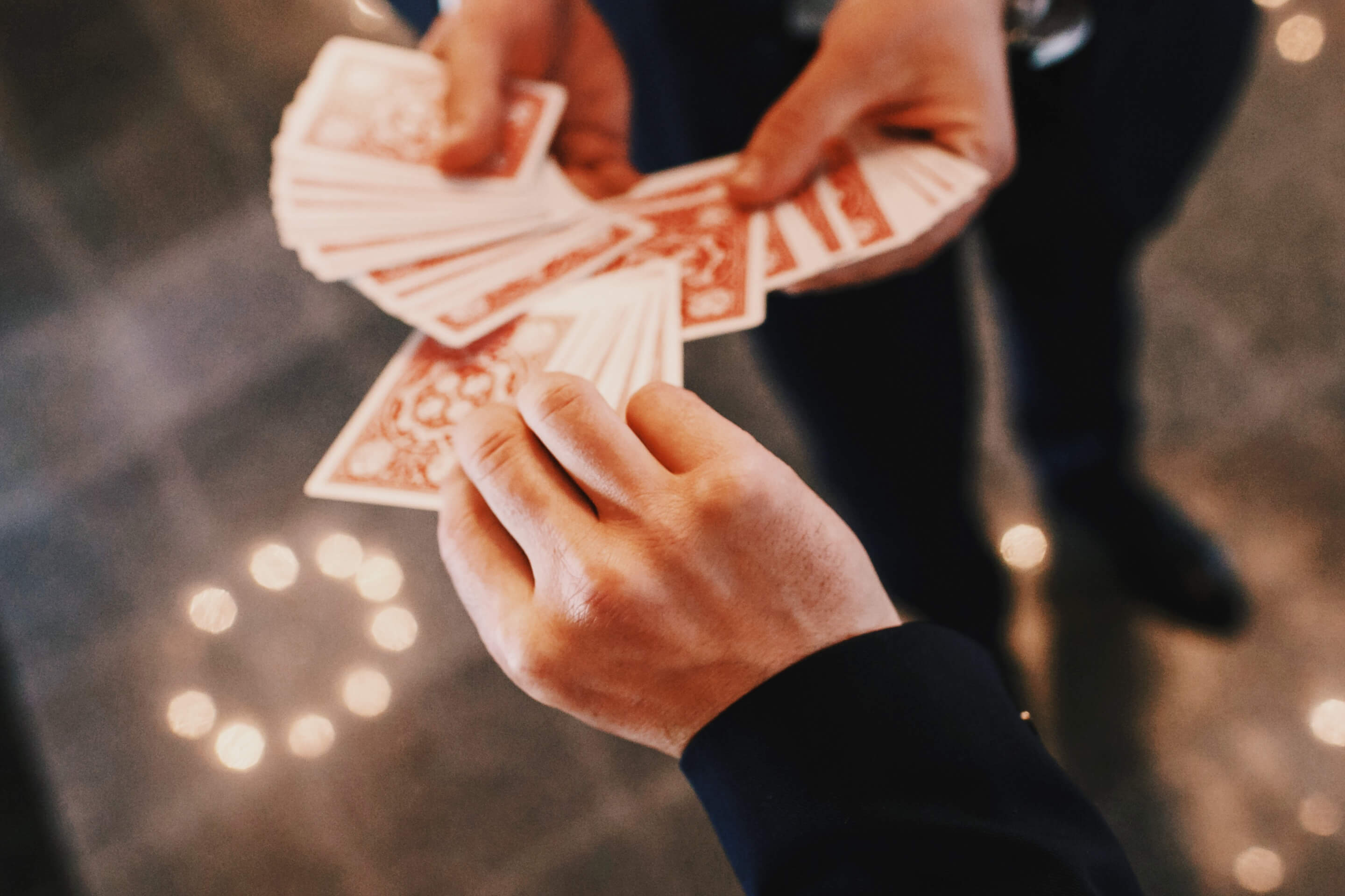 A volunteer picks a card from a magician's deck.
