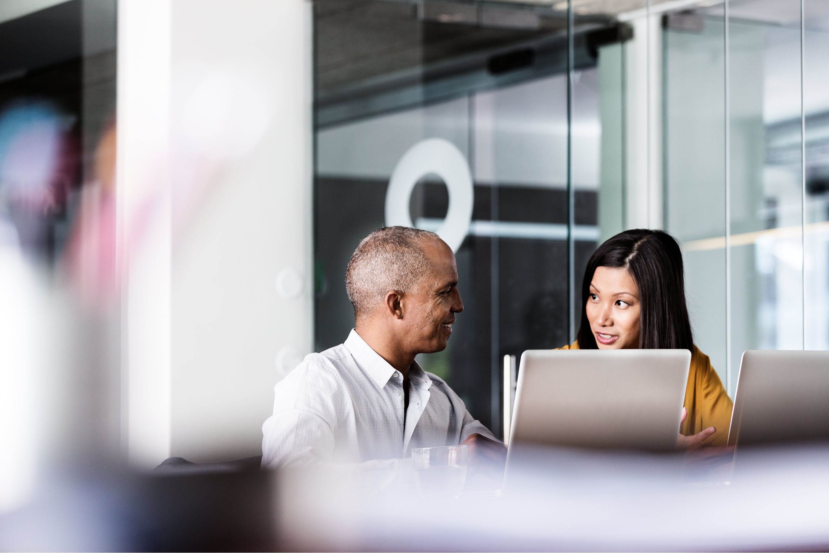 Business people discuss at a desk in the office.