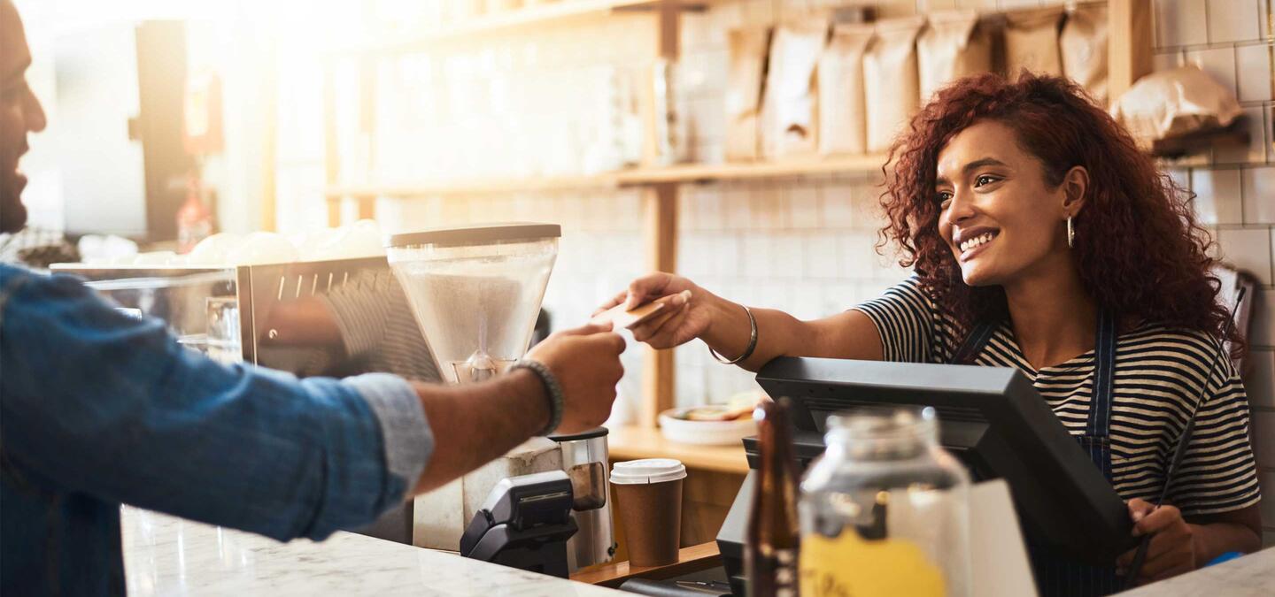 Person checking out order at a coffee shop with a credit card