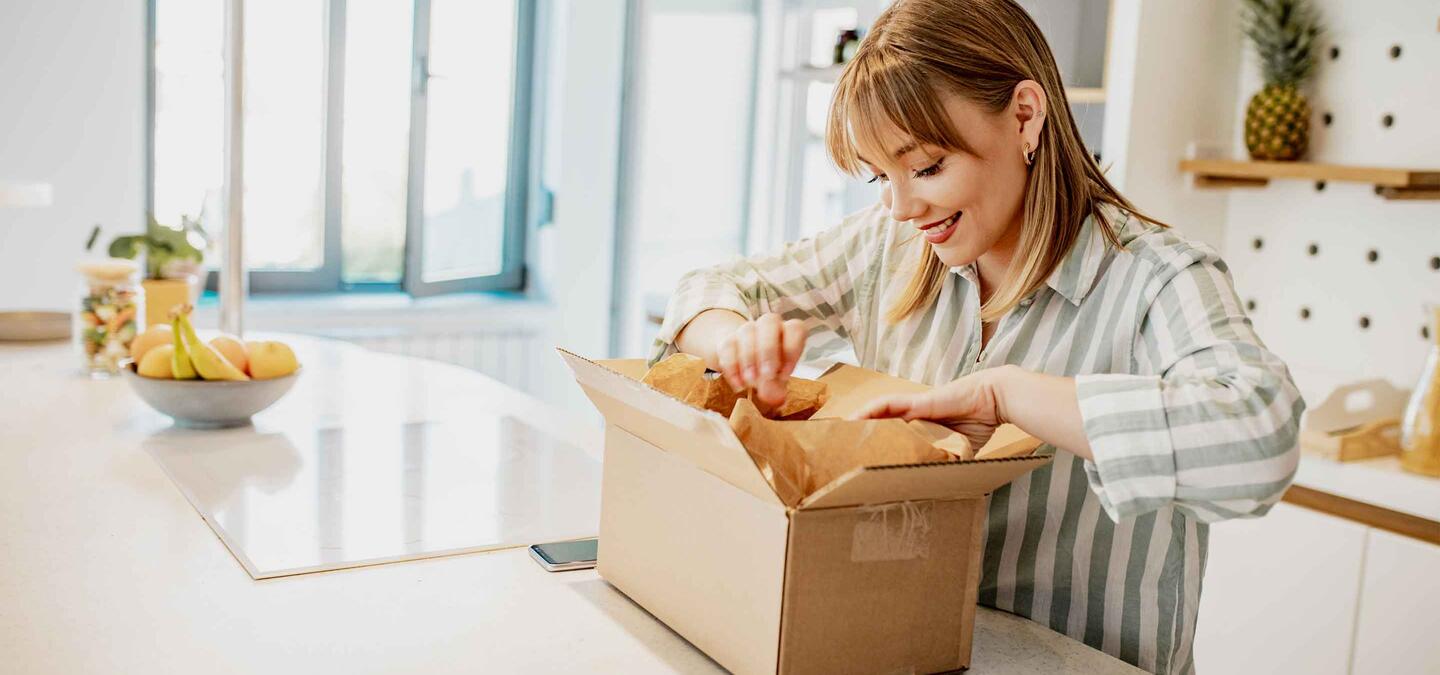 A young woman is at home, she unpacks delivered package