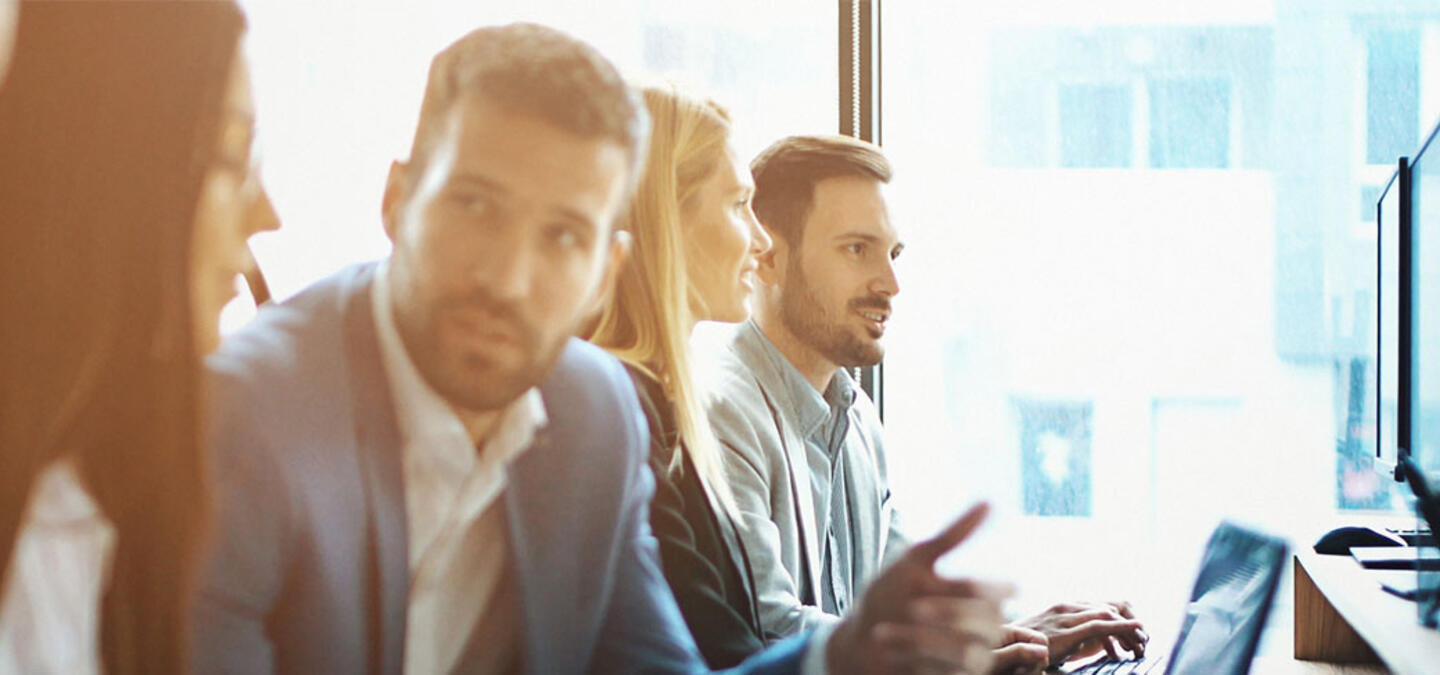 group of people talking at computers