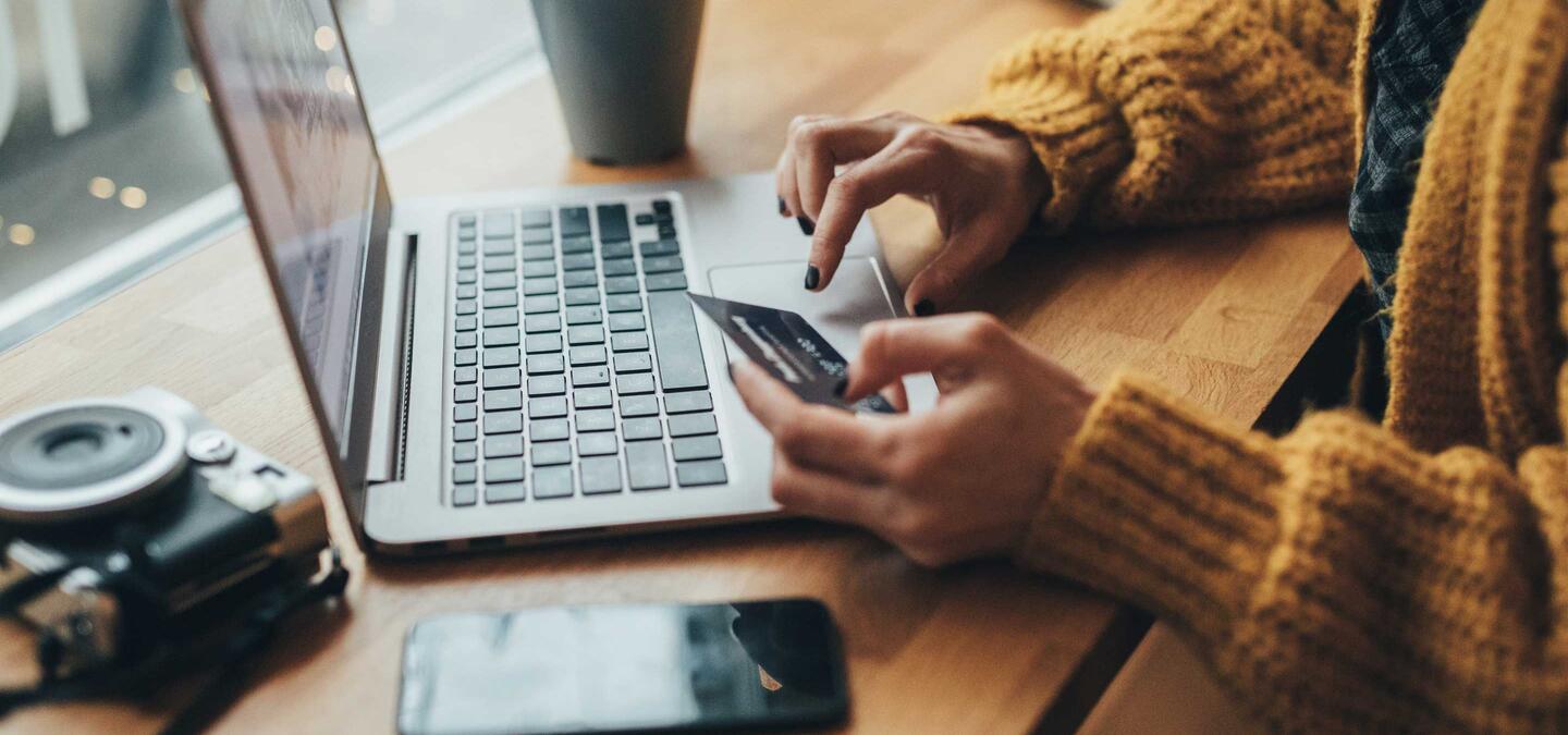 Woman in cafe shopping online with laptop
