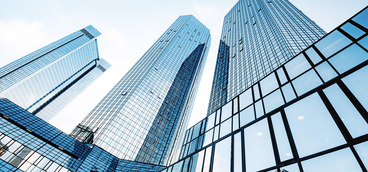 A perspective shot of a shiny and reflective enterprise business building, stretching tall into the sky