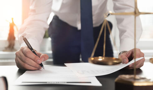 Man writing on paper on office desk