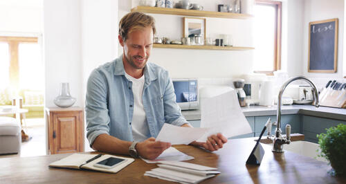 Person reviewing documents at their kitchen table