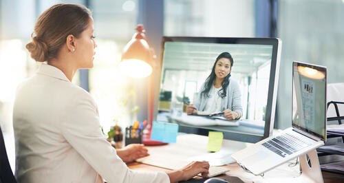 Two women meeting over a video conference on a computer