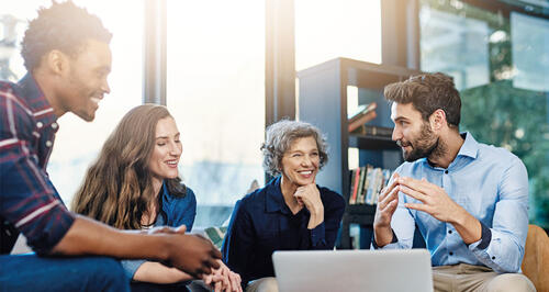 A group of individuals from a small business gathered around a table discussing business growth.