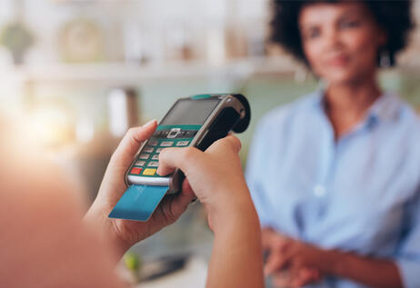 Person purchasing product using credit card payment terminal.