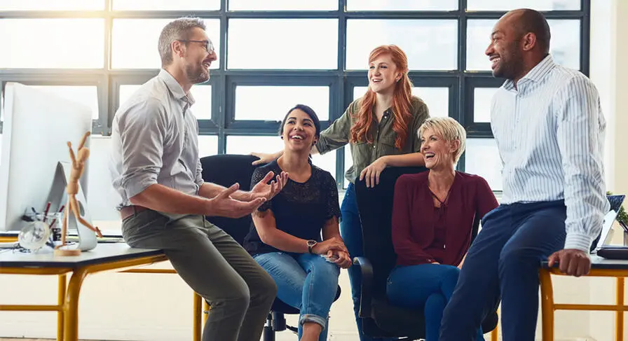 A group of coworkers gathered together discussing tax technology.