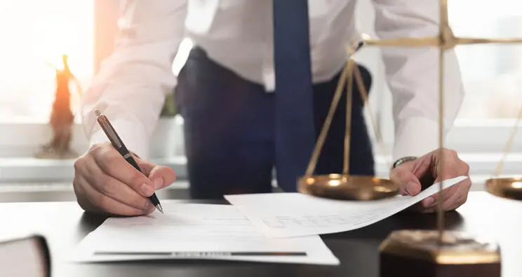 Man writing on paper on office desk