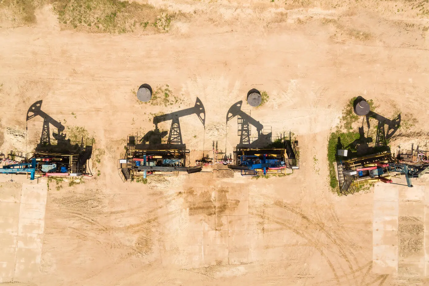 Stylized image of four oil refineries burned into a wooden background