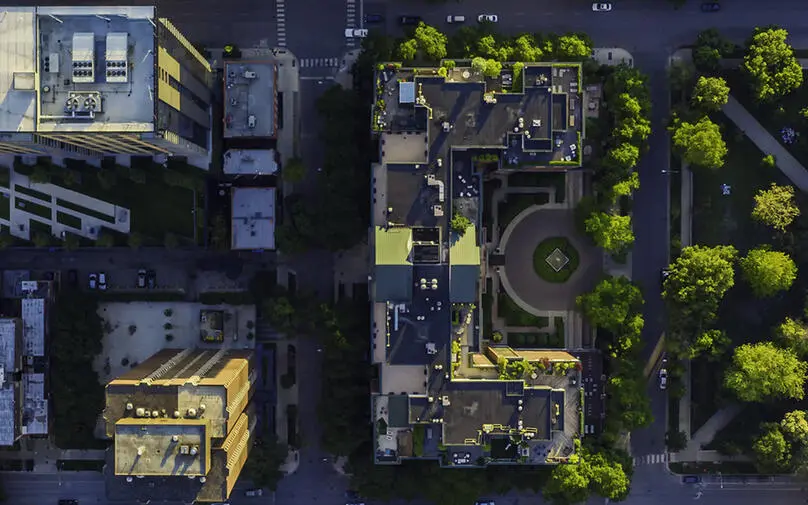 A birds-eye view of a city with plenty of greenery scattered throughout