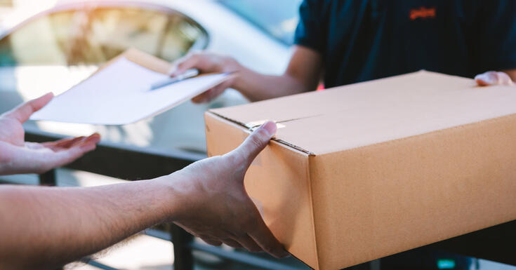 A customer signing for their package, which arrived thanks to address cleansing tax technology.